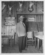 undated, Albert E. Cudlipp Sr. standing in Boggy Slough hunting lodge, Trinity County, Texas