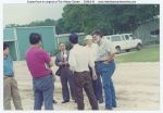1994, Zhao Binyi (Director of The General Station of Forest Pest Control #58 in Shenyang, China) standing in group with green building in background while visiting Jasper, Texas